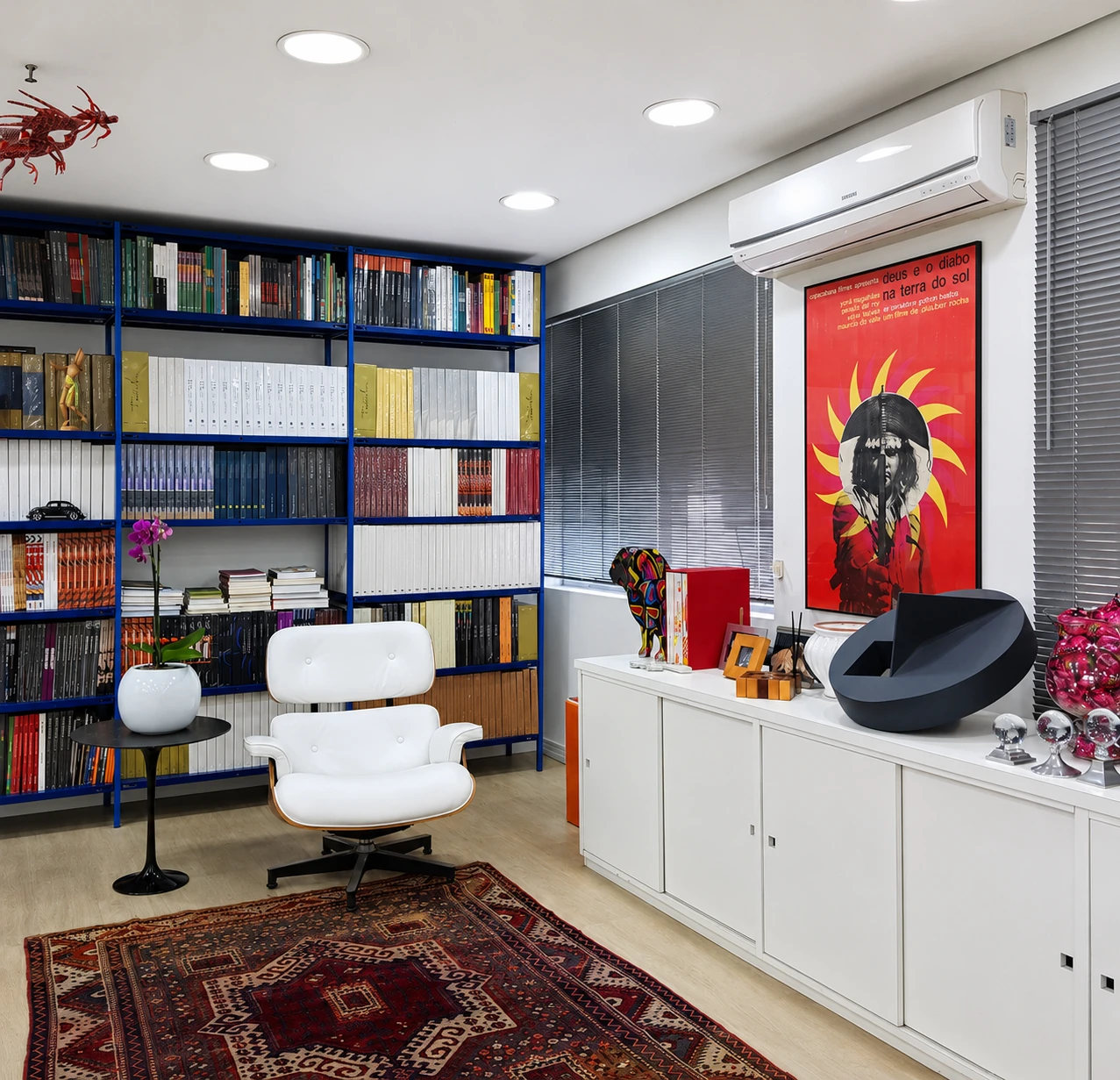 Interior do estúdio Via traço, com livros, arte e mobiliário de trabalho